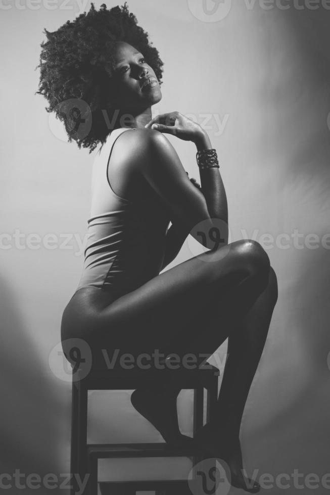 fotografia preto e branco de mulher negra sensual sob luz neon foto