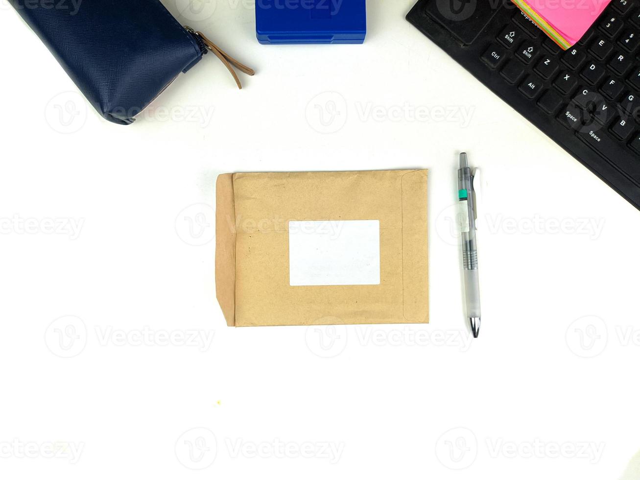 maquete de conjunto de artigos de papelaria de papel reciclado vazio com layout branco no centro e caneta ao lado, isolado contra o fundo branco da mesa de escritório foto