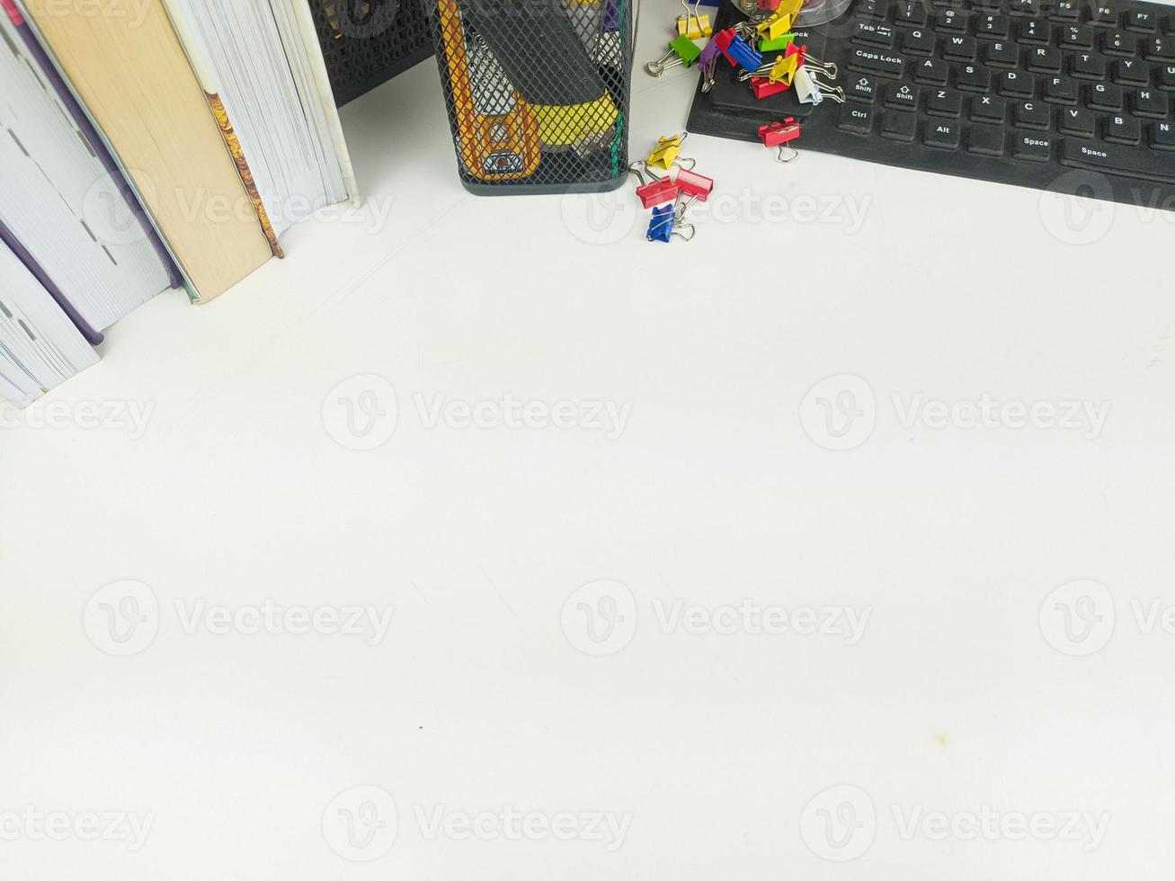 mesa plana e branca no escritório com espaço de layout. com equipamentos de escritório, como lápis, cadernos e teclados no topo. mesa simulada foto