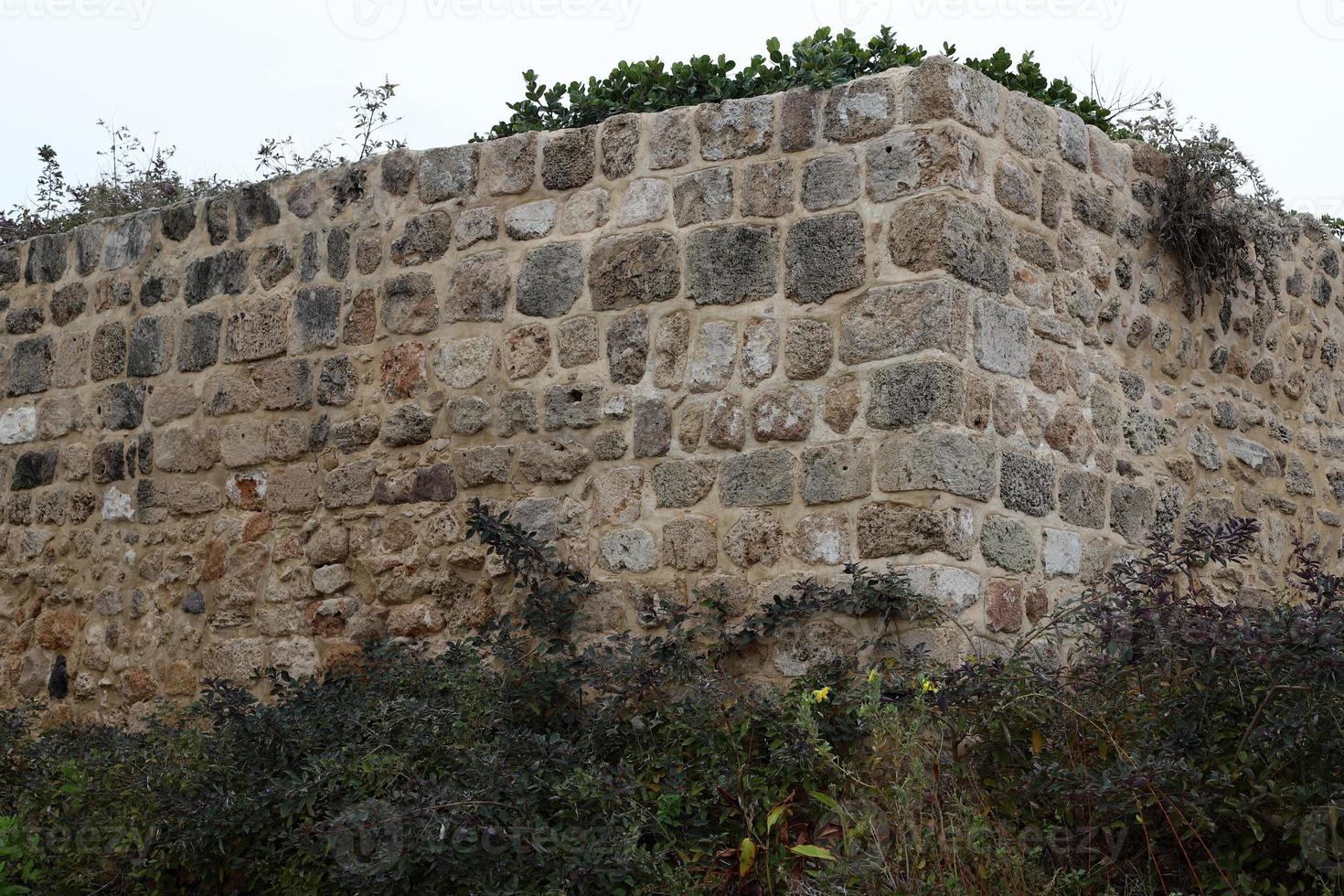 parede de pedra de uma antiga fortaleza à beira-mar em israel. foto