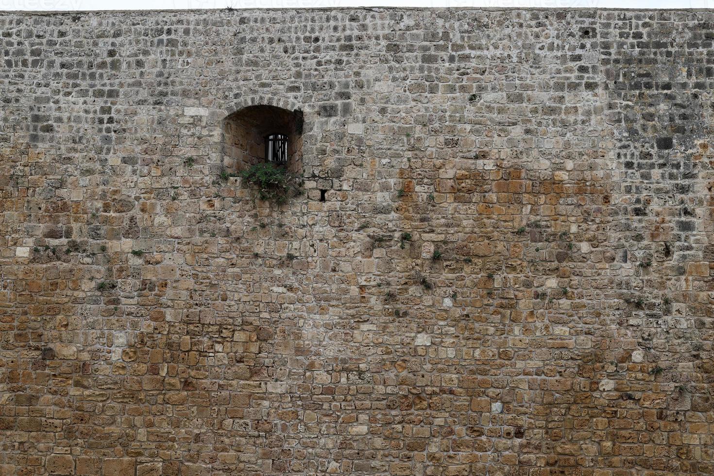 parede de pedra de uma antiga fortaleza à beira-mar em israel. foto