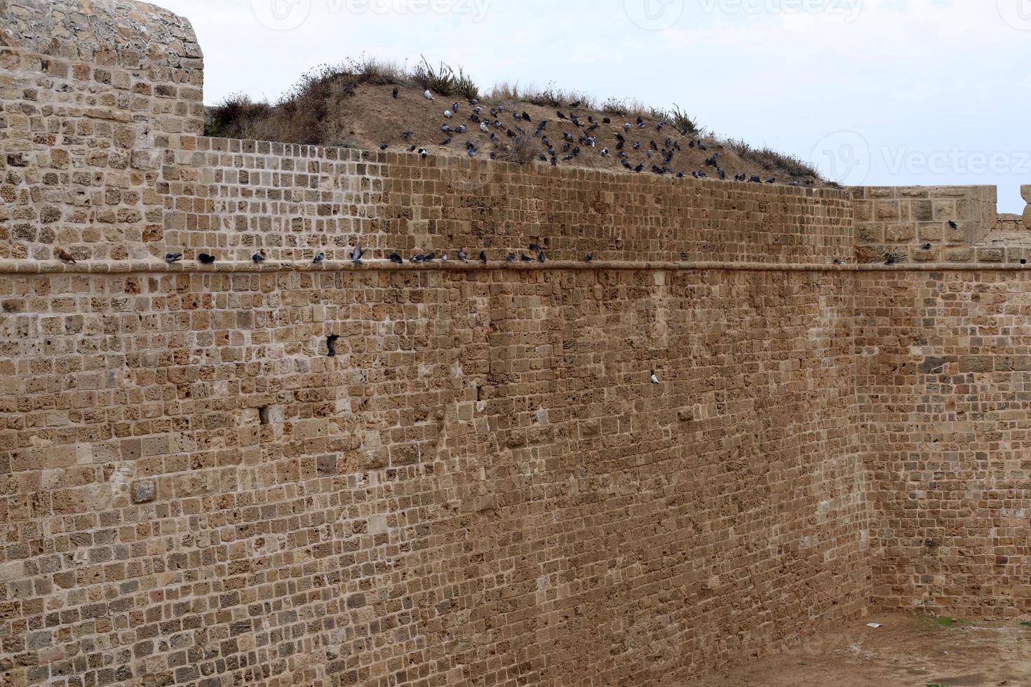 parede de pedra de uma antiga fortaleza à beira-mar em israel. foto