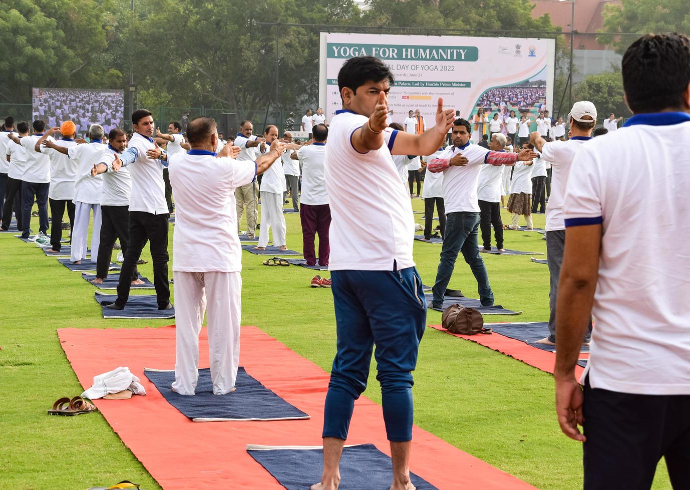 nova delhi, índia, 21 de junho de 2022 - sessão de exercícios de ioga em grupo para pessoas no complexo esportivo yamuna em delhi no dia internacional de ioga, grande grupo de adultos participando de aula de ioga no estádio de críquete foto