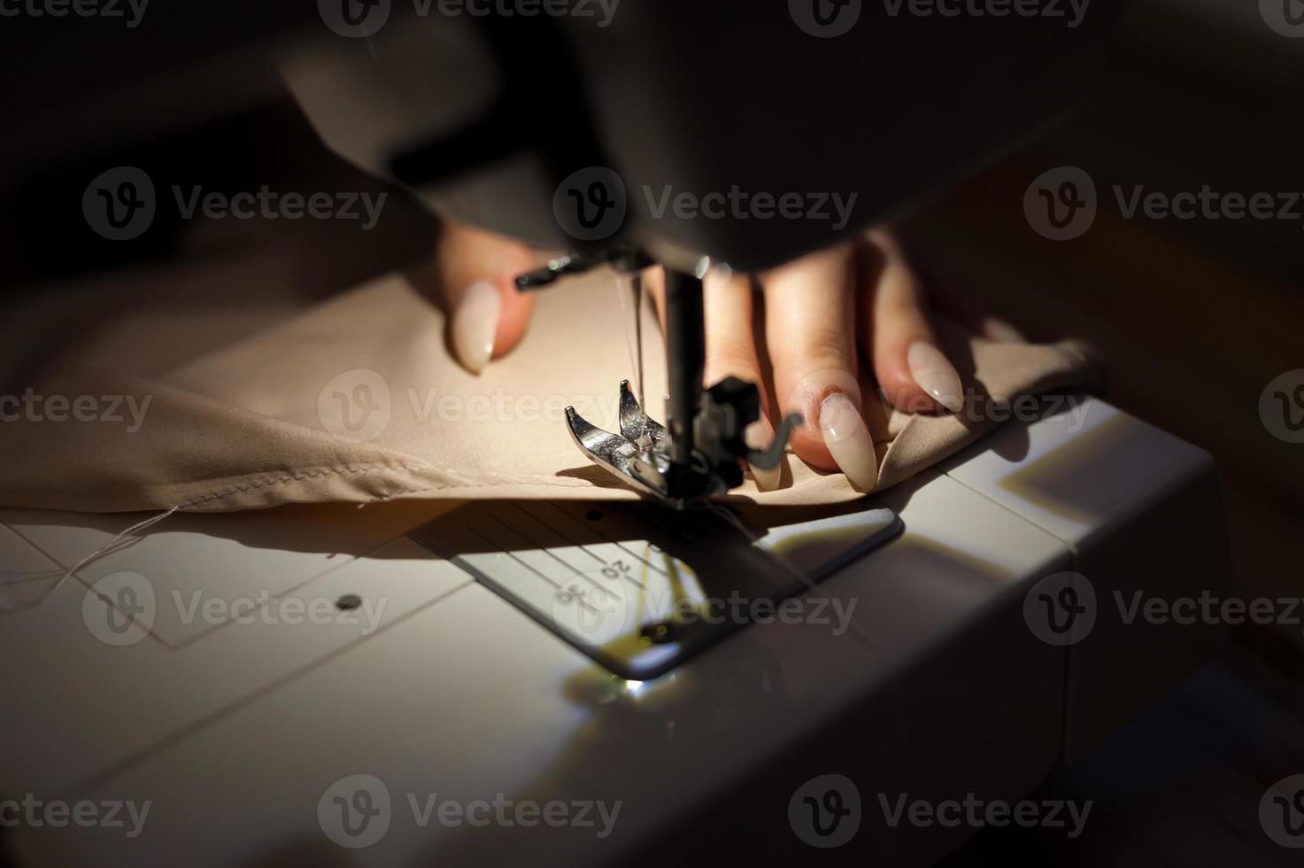 a mulher está costurando com máquina de costura. a costura é uma das artes têxteis mais antigas. foto