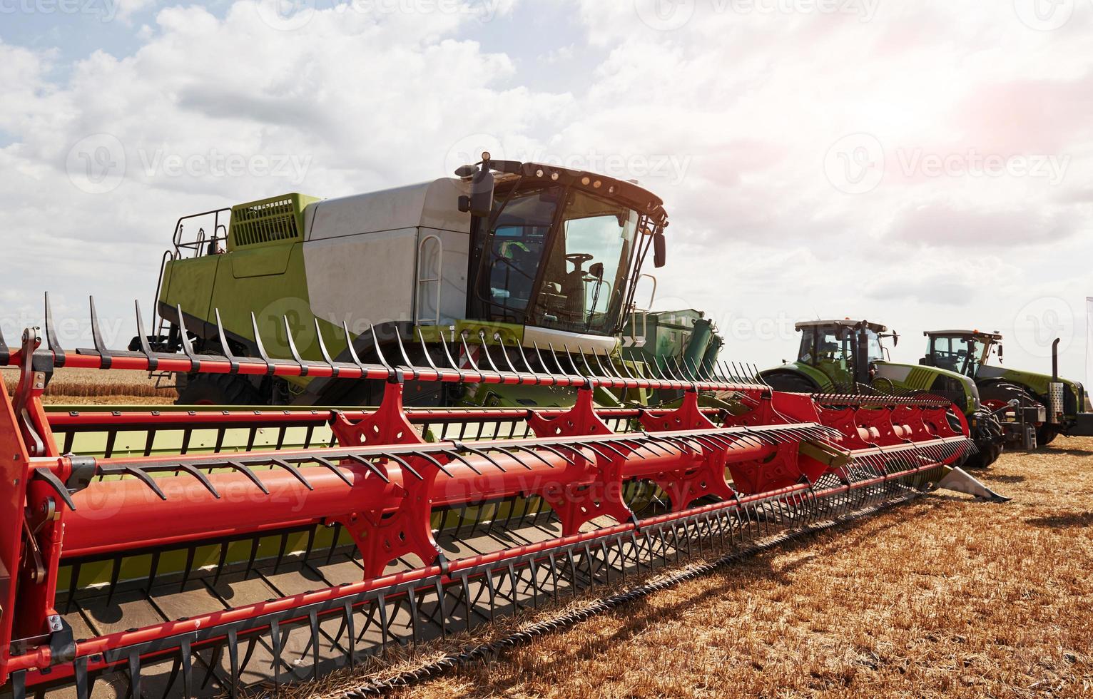 grandes colheitadeiras estacionadas no campo agrícola no verão foto