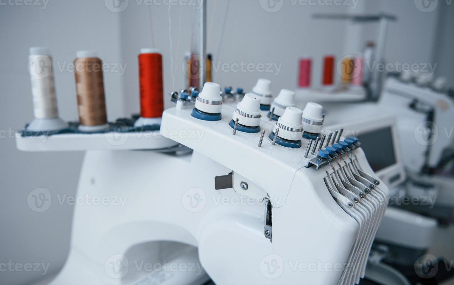 close-up vista da máquina de costura automática branca na fábrica foto