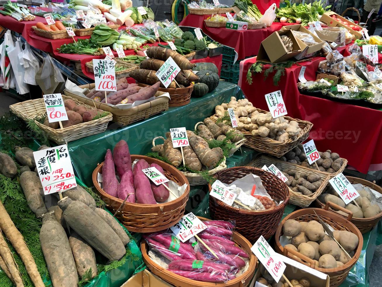 vegetais frescos e raízes colocados nas prateleiras do mercado kuromon ichiba para esperar que os clientes façam compras para cozinhar em casa. foto