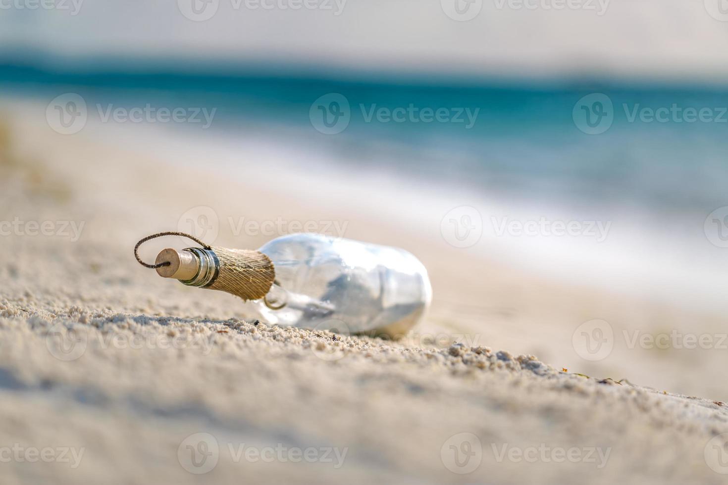 mensagem na garrafa lavada em terra contra o pôr do sol. garrafa com uma mensagem foto