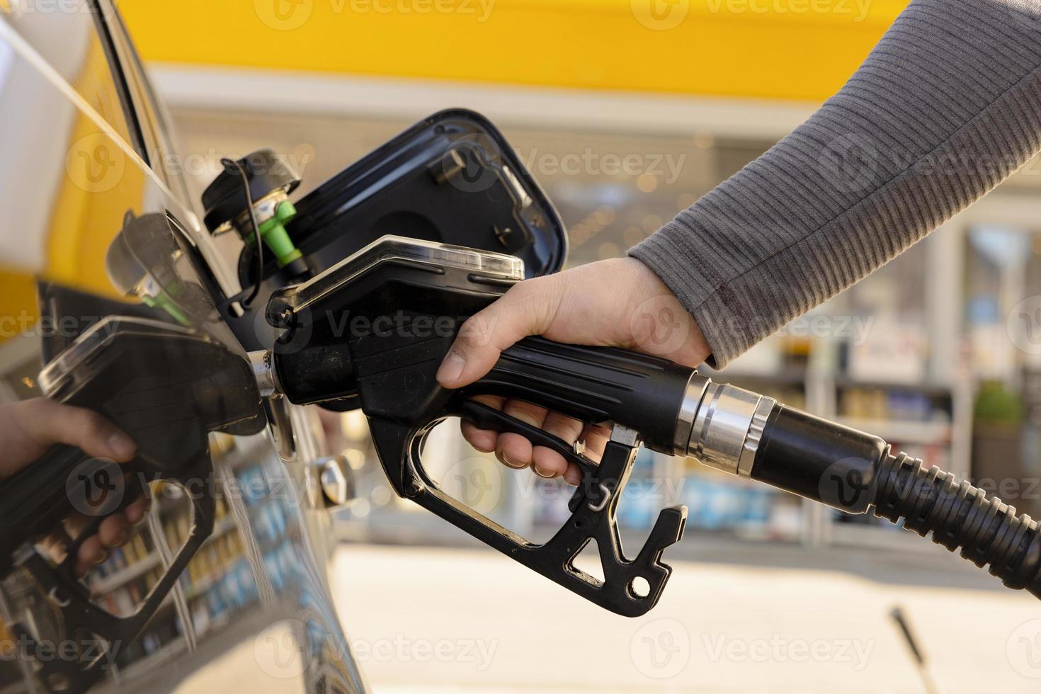 carro reabastecimento no posto de gasolina. homem reabastecer o carro com combustível. vista de perto. gasolina, o diesel está ficando mais caro. indústria petrolífera e serviços. preço da gasolina e conceito de crise do petróleo. foto