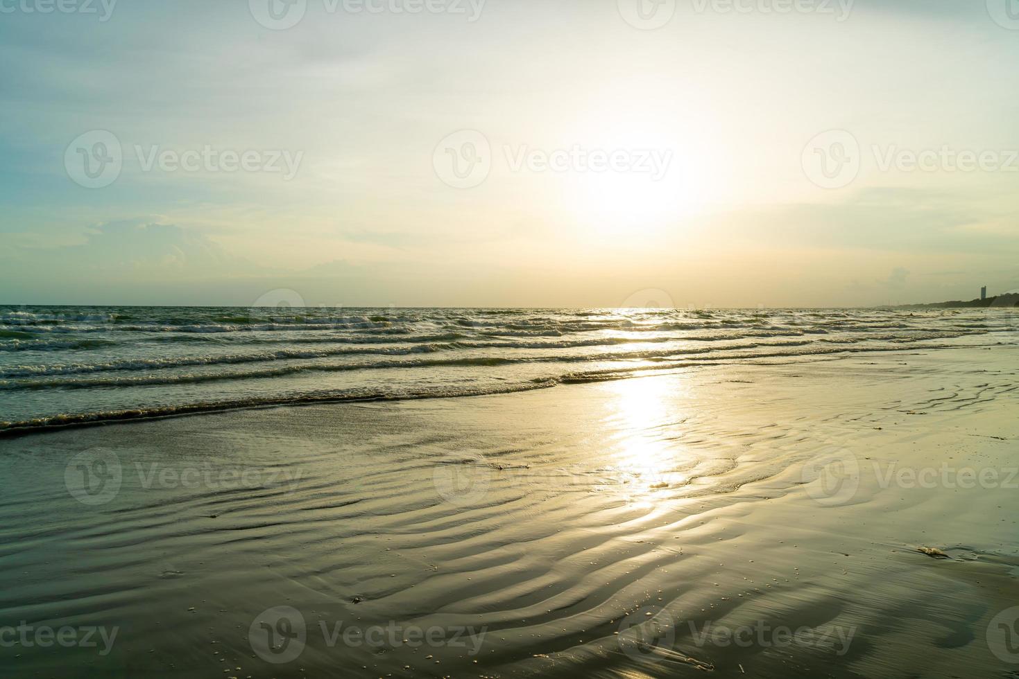 bela praia do mar com hora do pôr do sol foto