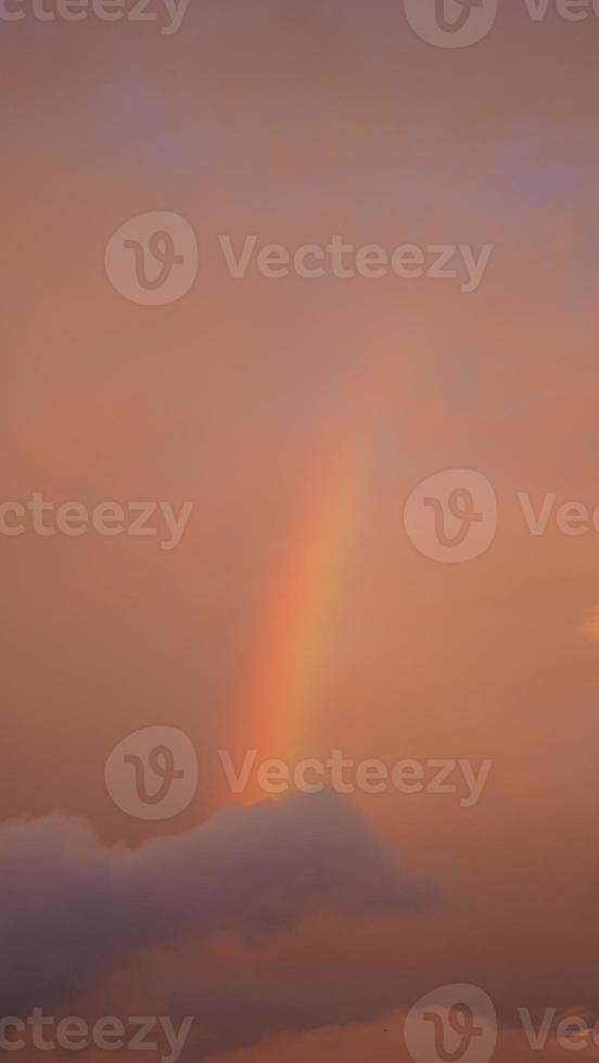 o arco-íris colorido subindo no céu depois da chuva de verão foto