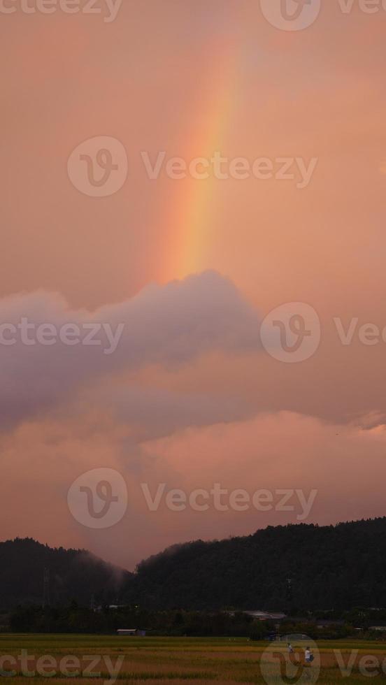 o arco-íris colorido subindo no céu depois da chuva de verão foto