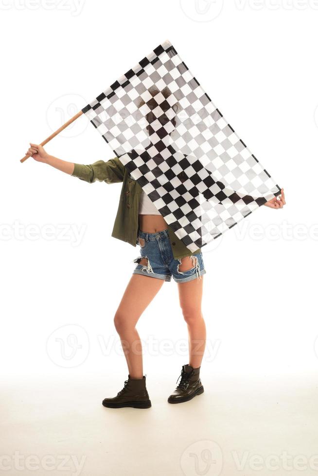 bela modelo segurando a bandeira de acabamento isolada no fundo branco. bandeira de chegada do automobilismo nas mãos de um modelo feminino. foto