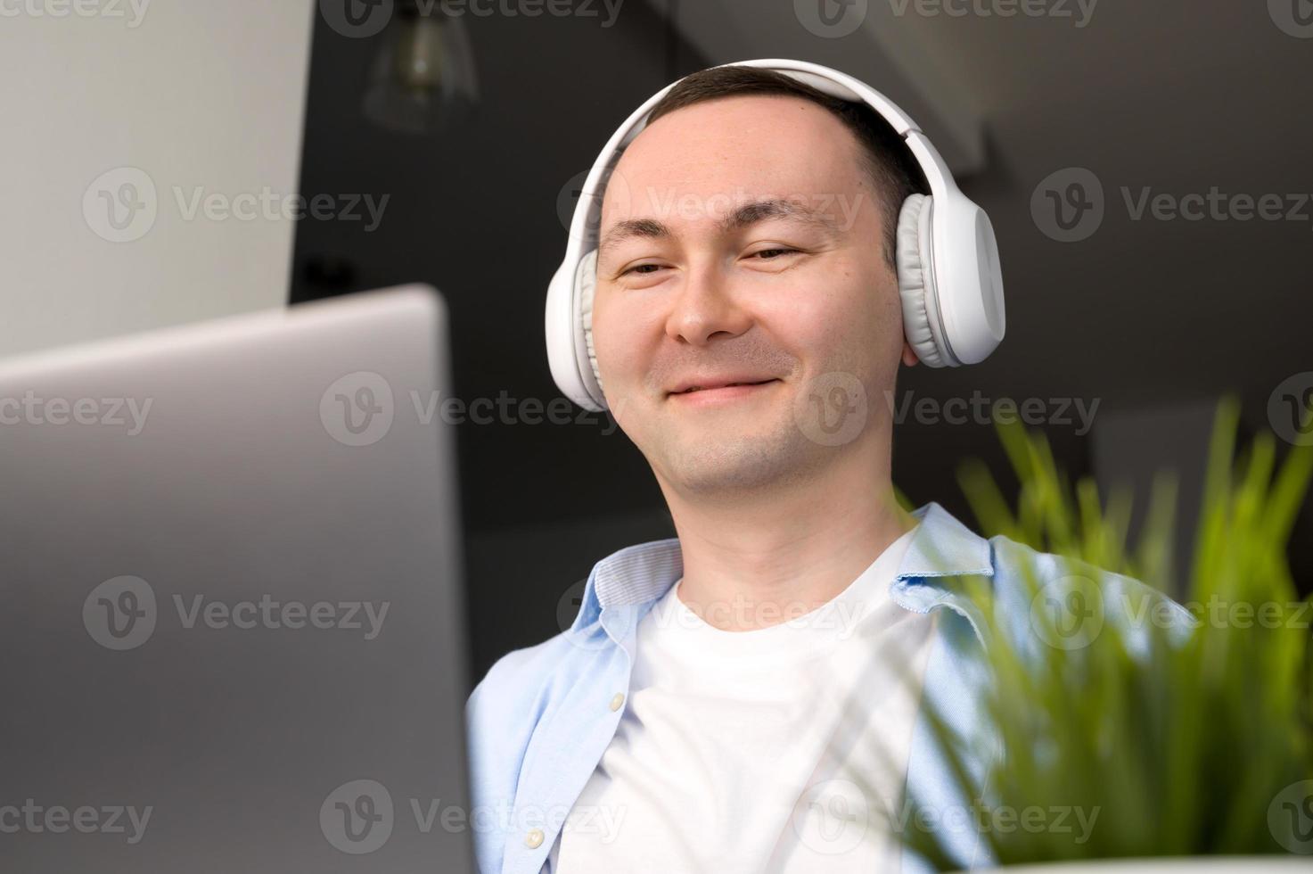 retrato de homem asiático feliz com fones de ouvido ouvindo palestra, podcast, música e trabalho trabalho e educação online foto