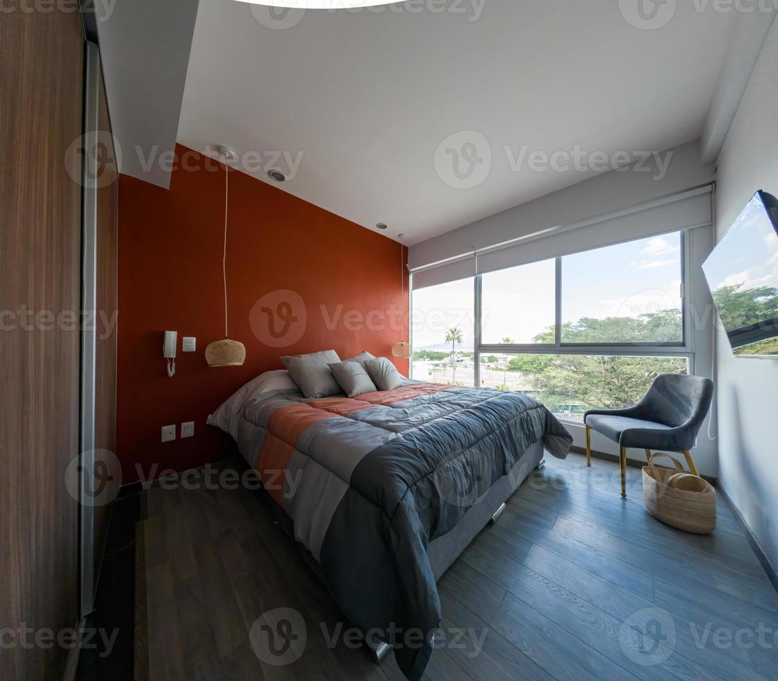 interior elegante do quarto contemporâneo com mobiliário confortável. cama para dois com cobertor foto