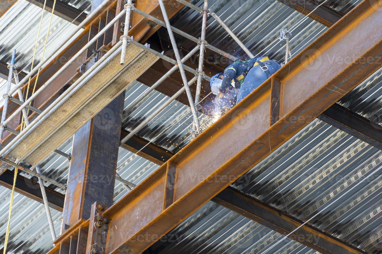homem soldando aço em uma viga em altura, estrutura de construção, méxico guadalajara foto