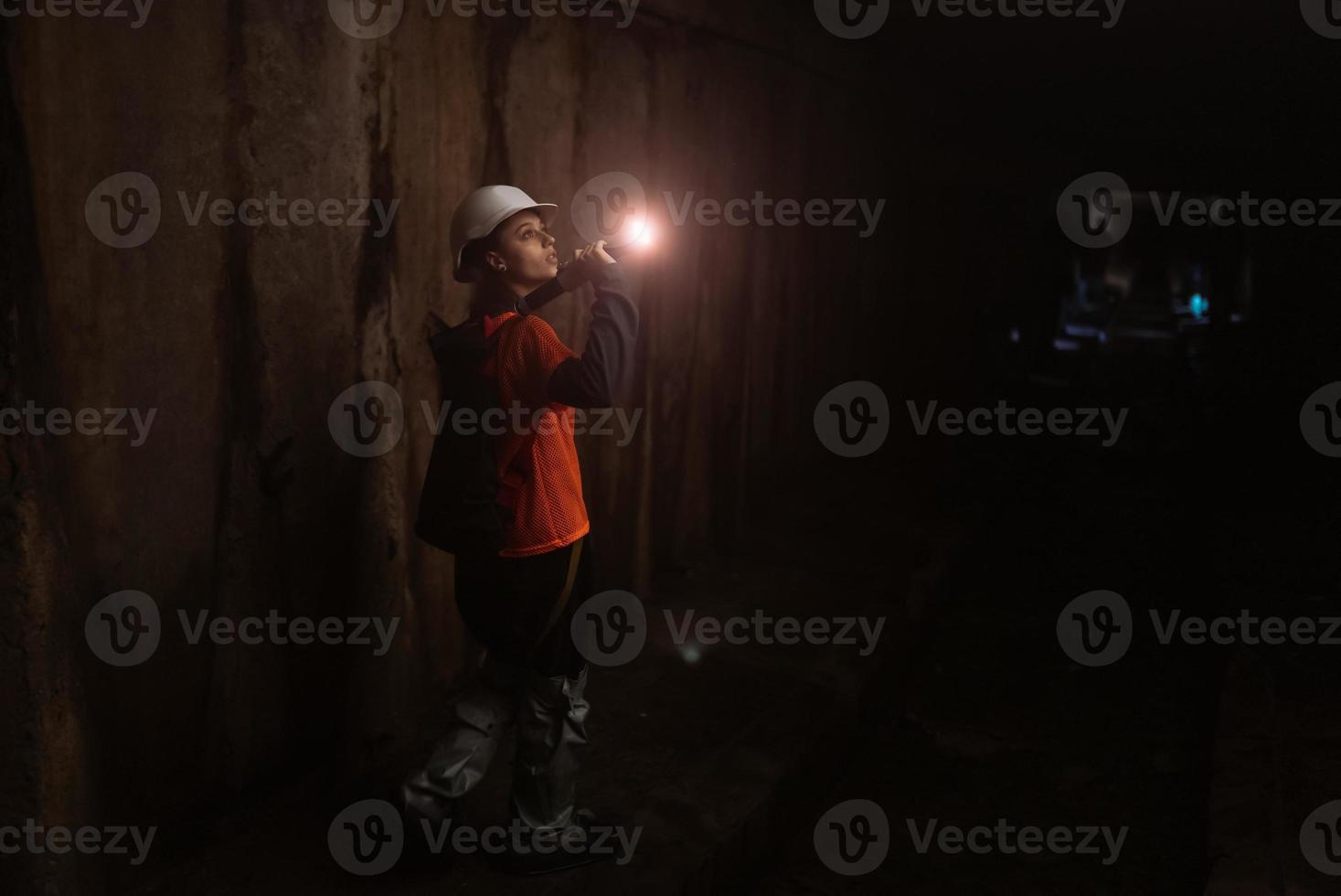 escavadora feminina com lanterna explora o túnel foto