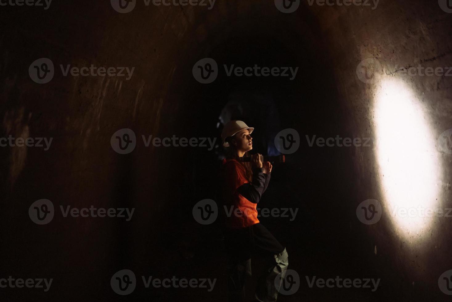 escavadora feminina com lanterna explora o túnel foto