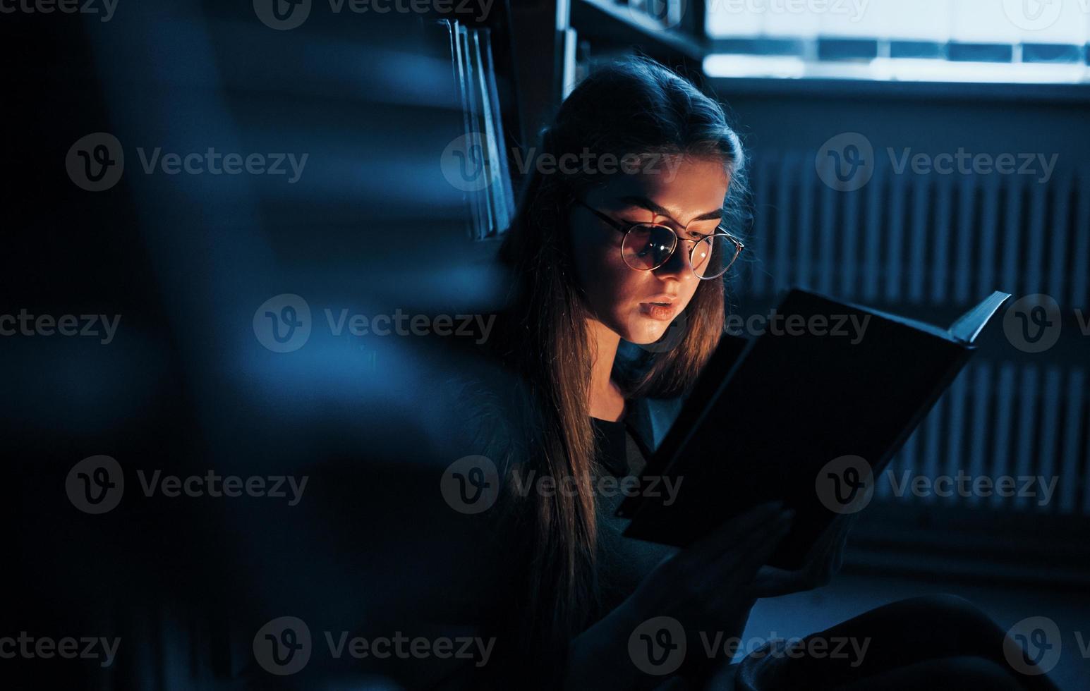 ficando mais inteligente a cada dia. aluna está na biblioteca cheia de livros. concepção de educação foto