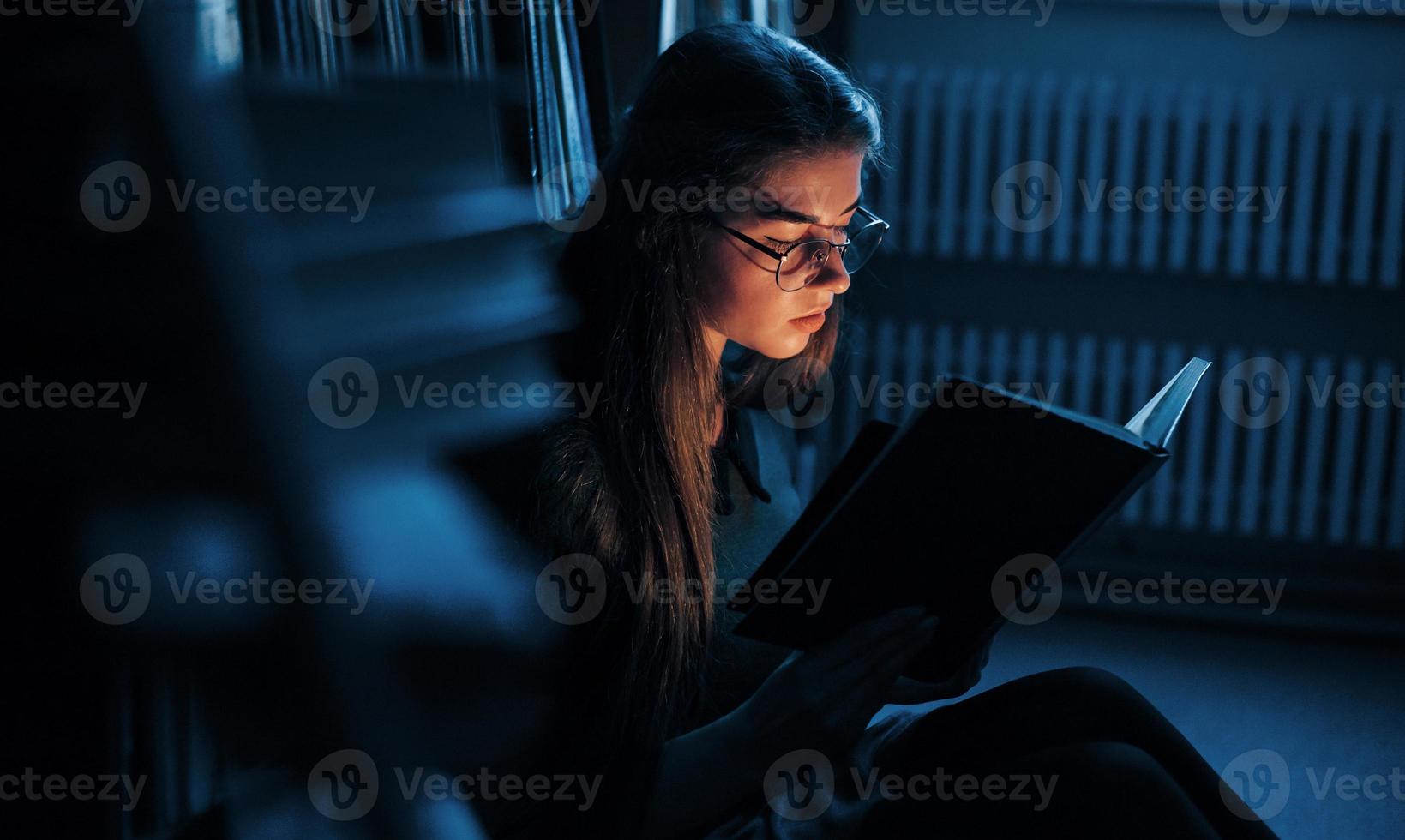 ficando mais inteligente a cada dia. aluna está na biblioteca cheia de livros. concepção de educação foto