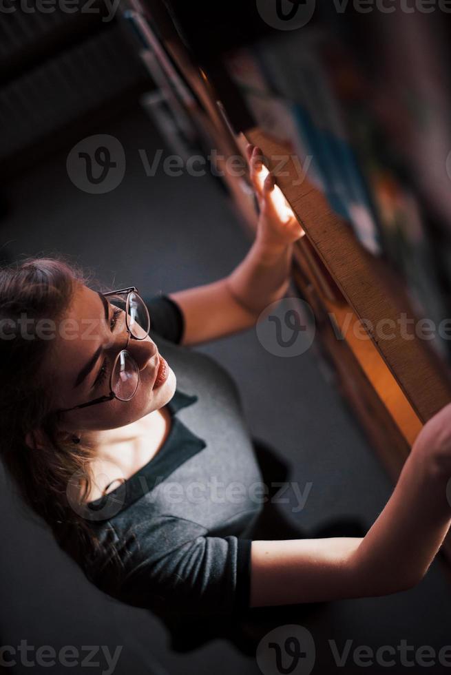 vista aérea. aluna está na biblioteca cheia de livros. concepção de educação foto