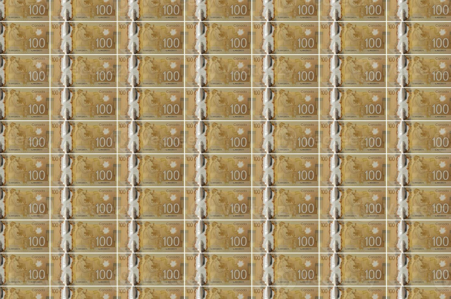 Notas de 100 dólares canadenses impressas no transportador de produção de dinheiro. colagem de muitas contas. conceito de desvalorização da moeda foto