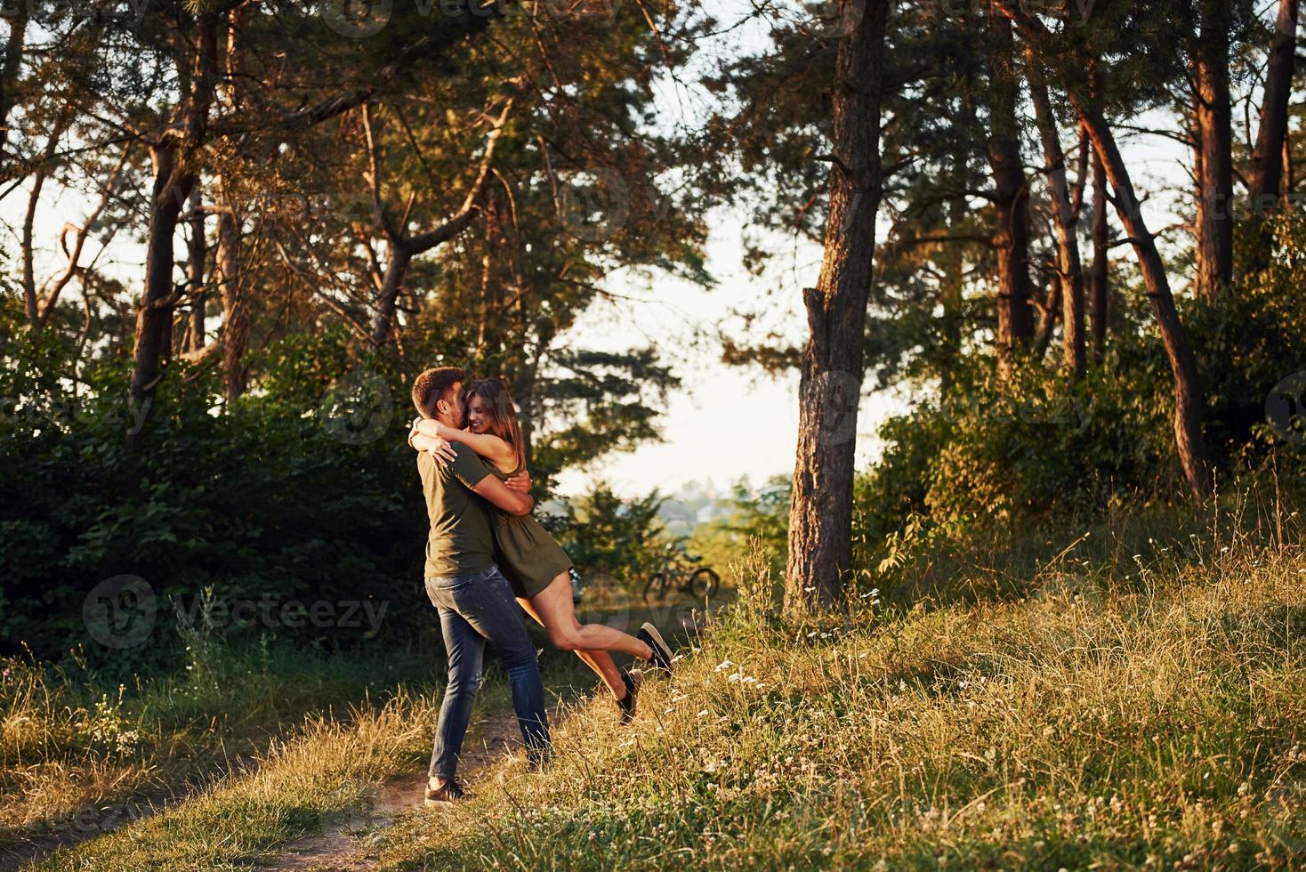 lindo casal jovem se diverte na floresta durante o dia foto