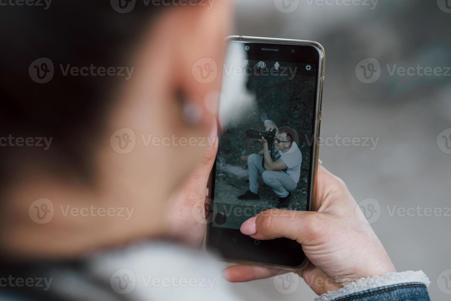 menina tirando foto de fotógrafo profissional usando seu telefone