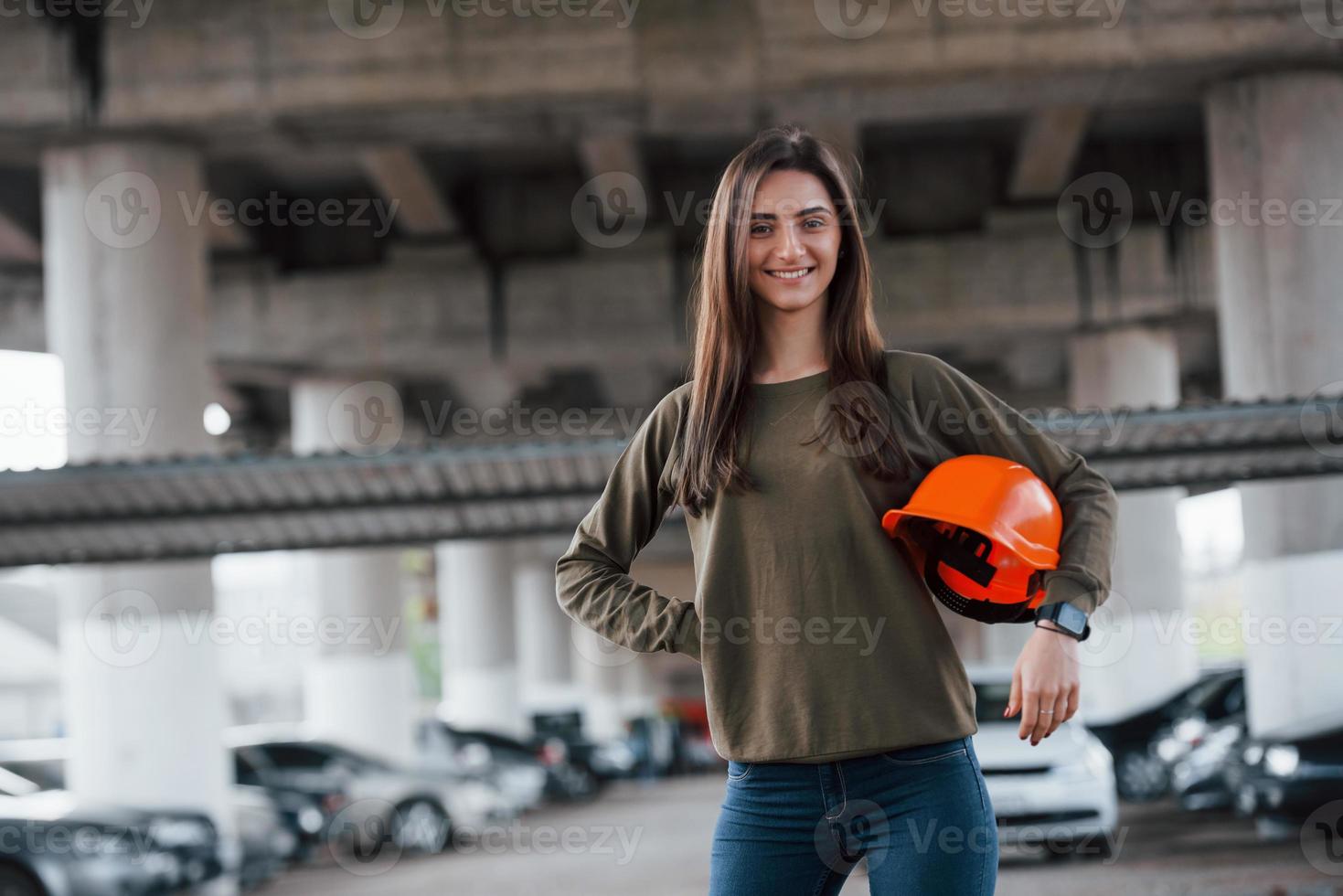 pessoa fofa. retrato de mulher jovem e bonita com capacete de segurança em pé debaixo da ponte foto