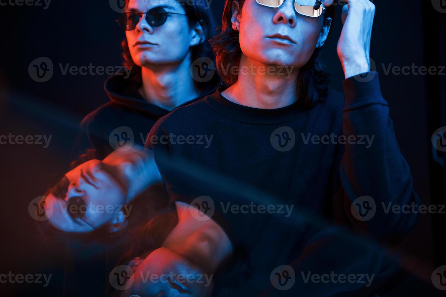 reflexão clara. retrato de irmãos gêmeos. estúdio filmado em estúdio escuro com luz neon foto