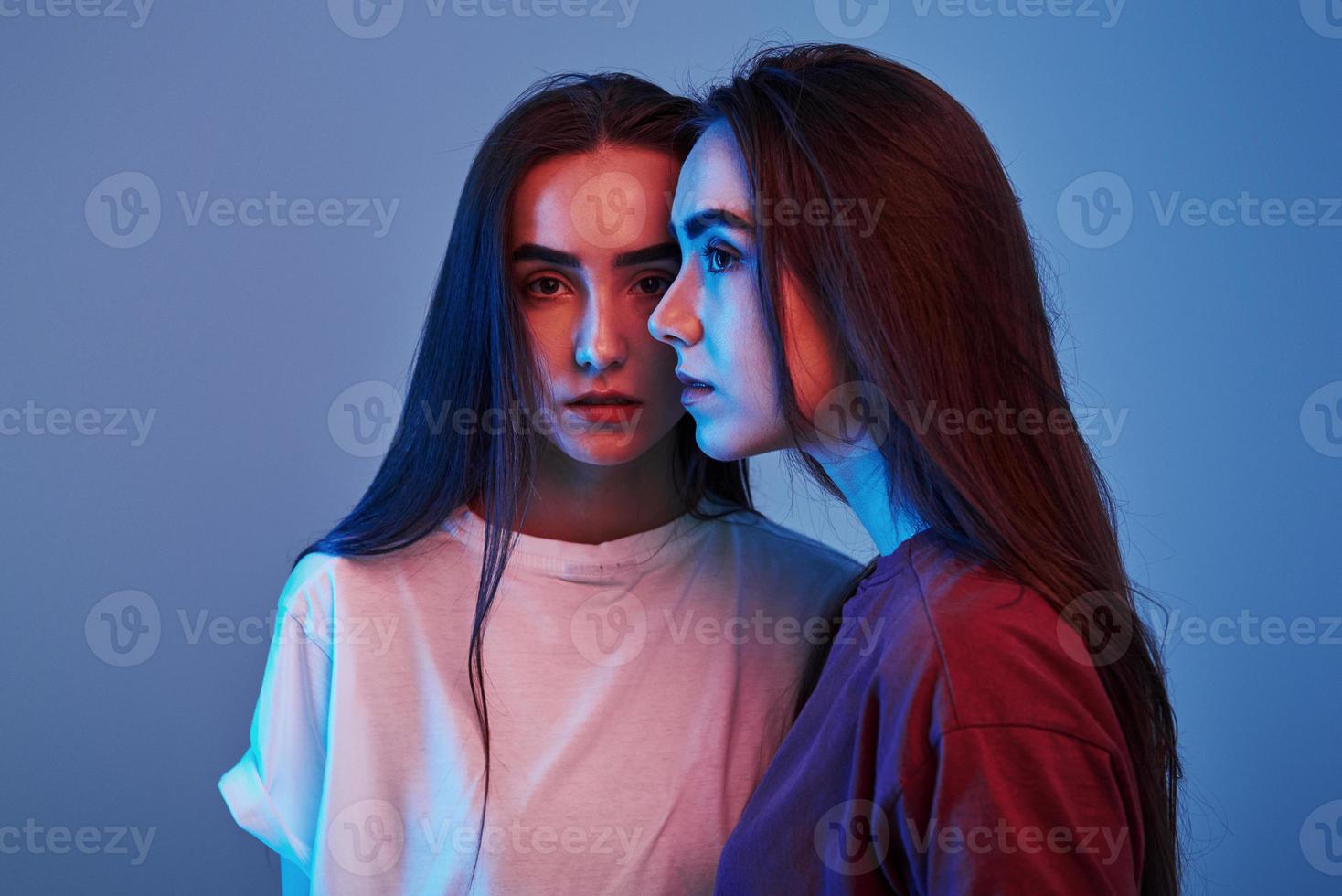 pessoas bonitas. estúdio filmado dentro de casa com luz neon. foto de duas lindas gêmeas