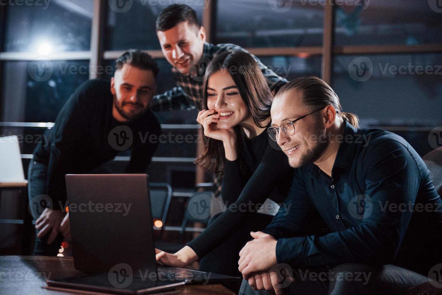 energia de amigos felizes. equipe de jovens empresários trabalha em seu projeto à noite no escritório foto