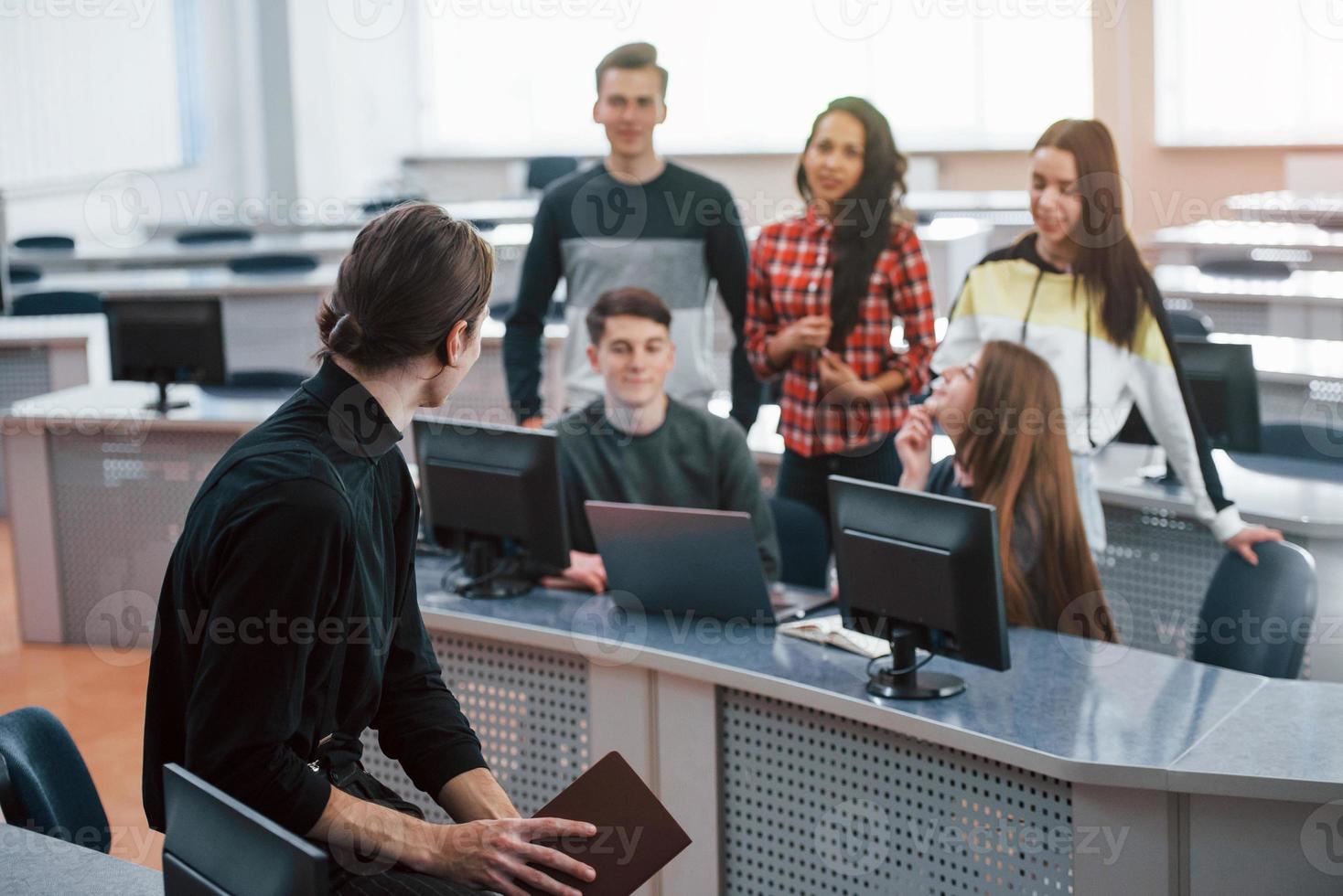 tendo um discurso. grupo de jovens em roupas casuais trabalhando no escritório moderno foto