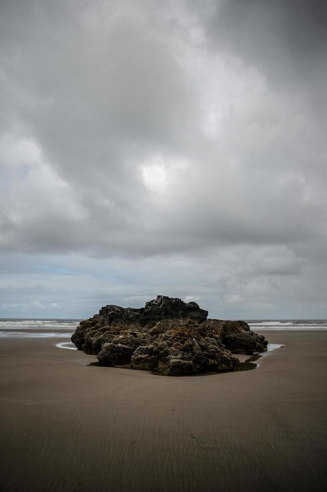formação de rocha marrom em uma praia foto