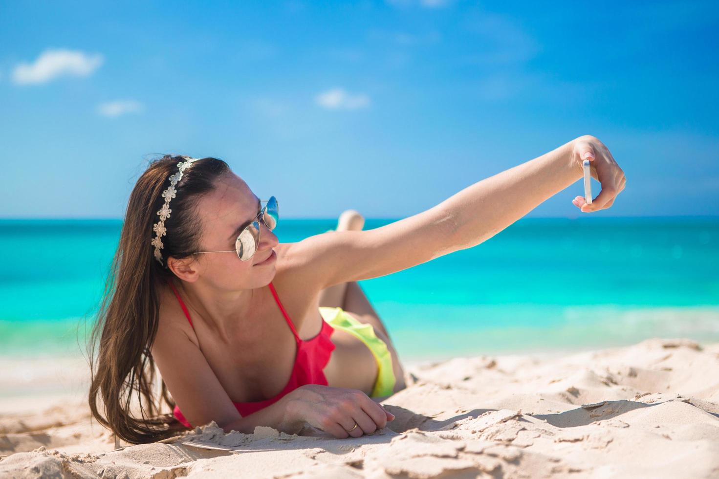 mulher tirando uma selfie na praia foto