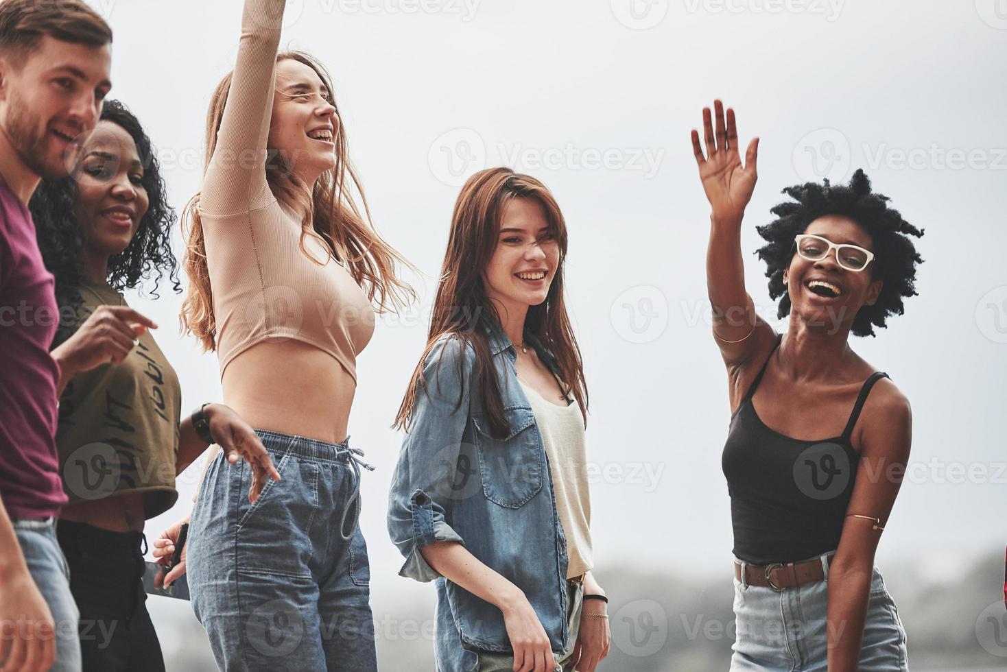 Olá para o fotógrafo. as pessoas fazem festa lá fora. amigos multiétnicos se encontram no fim de semana foto