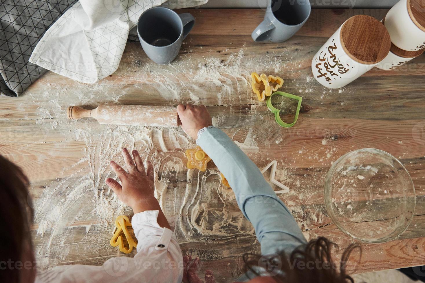 uma vez que eles se tornarão grandes chefs. agora é só se divertir. visão superior das crianças aprendendo a preparar comida da farinha com instrumentos formados especiais foto