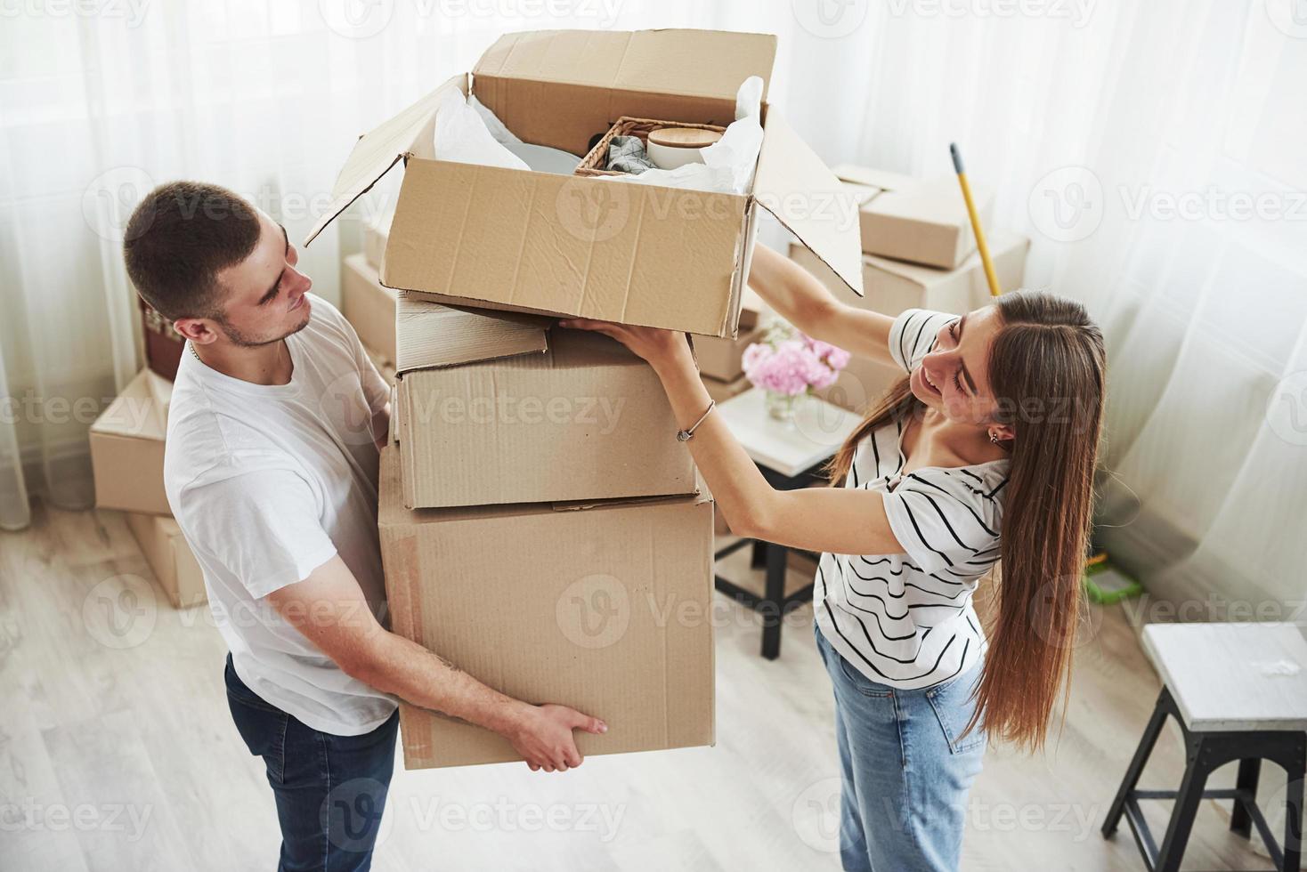 um monte de caixas. casal jovem alegre em seu novo apartamento. concepção de movimento foto