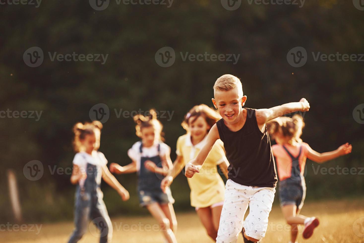 crianças correndo no campo em dia ensolarado. concepção de estilo de vida saudável foto