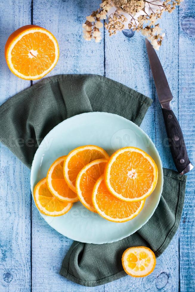 laranja suculenta fresca em fatias em um prato na mesa. comida saudável. vista superior e vertical foto
