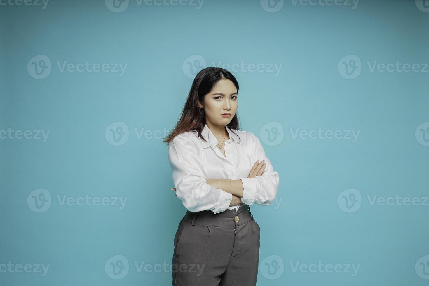 uma jovem asiática insatisfeita parece descontente vestindo camisa branca expressões faciais irritadas foto