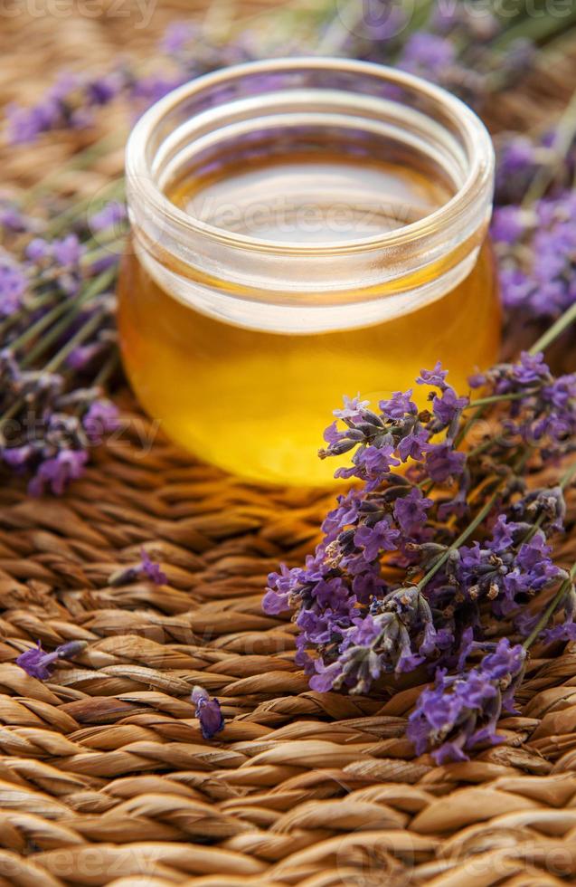 jarra com mel e flores frescas de lavanda foto