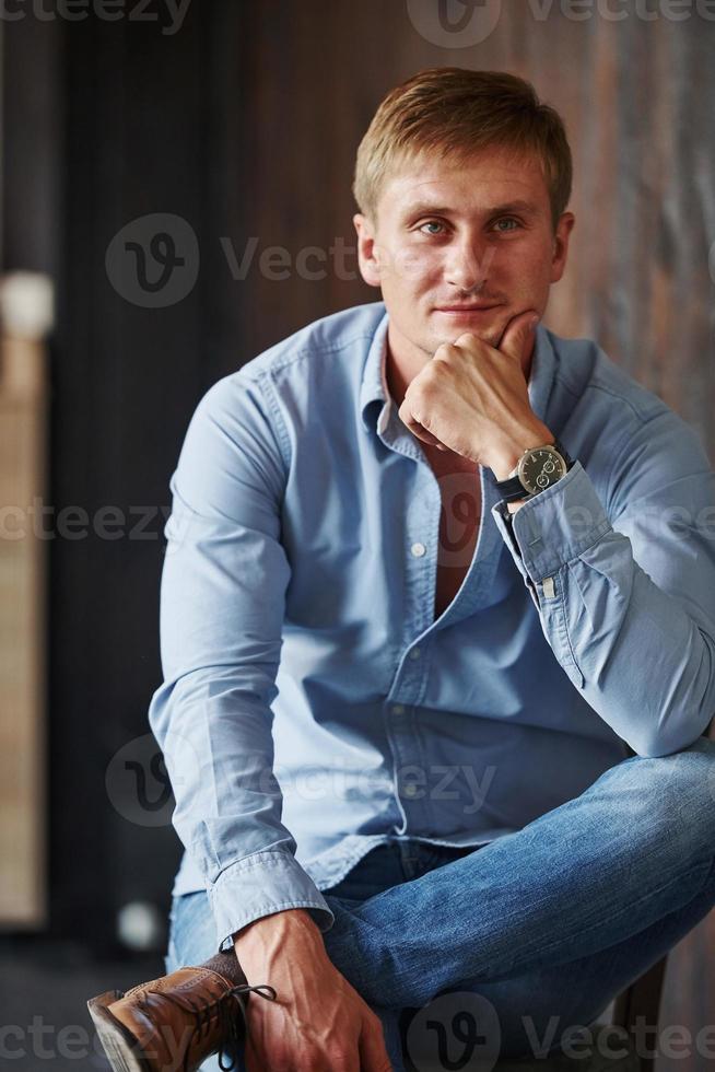 retrato de homem com camisa oficial que posa para a câmera dentro de casa foto