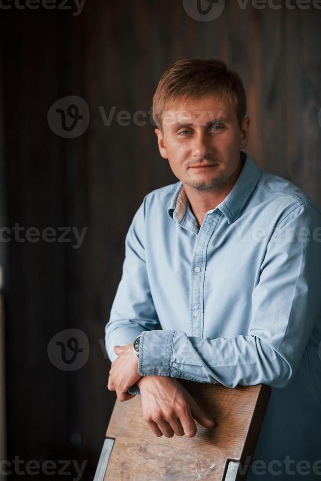 retrato de homem com camisa oficial que posa para a câmera dentro de casa foto