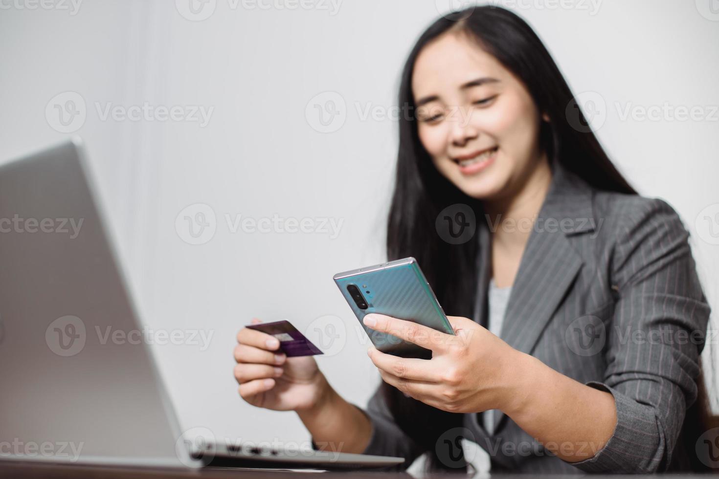 as mãos das mulheres segurando um cartão de crédito e trabalham no pagamento on-line do laptop para compras on-line foto