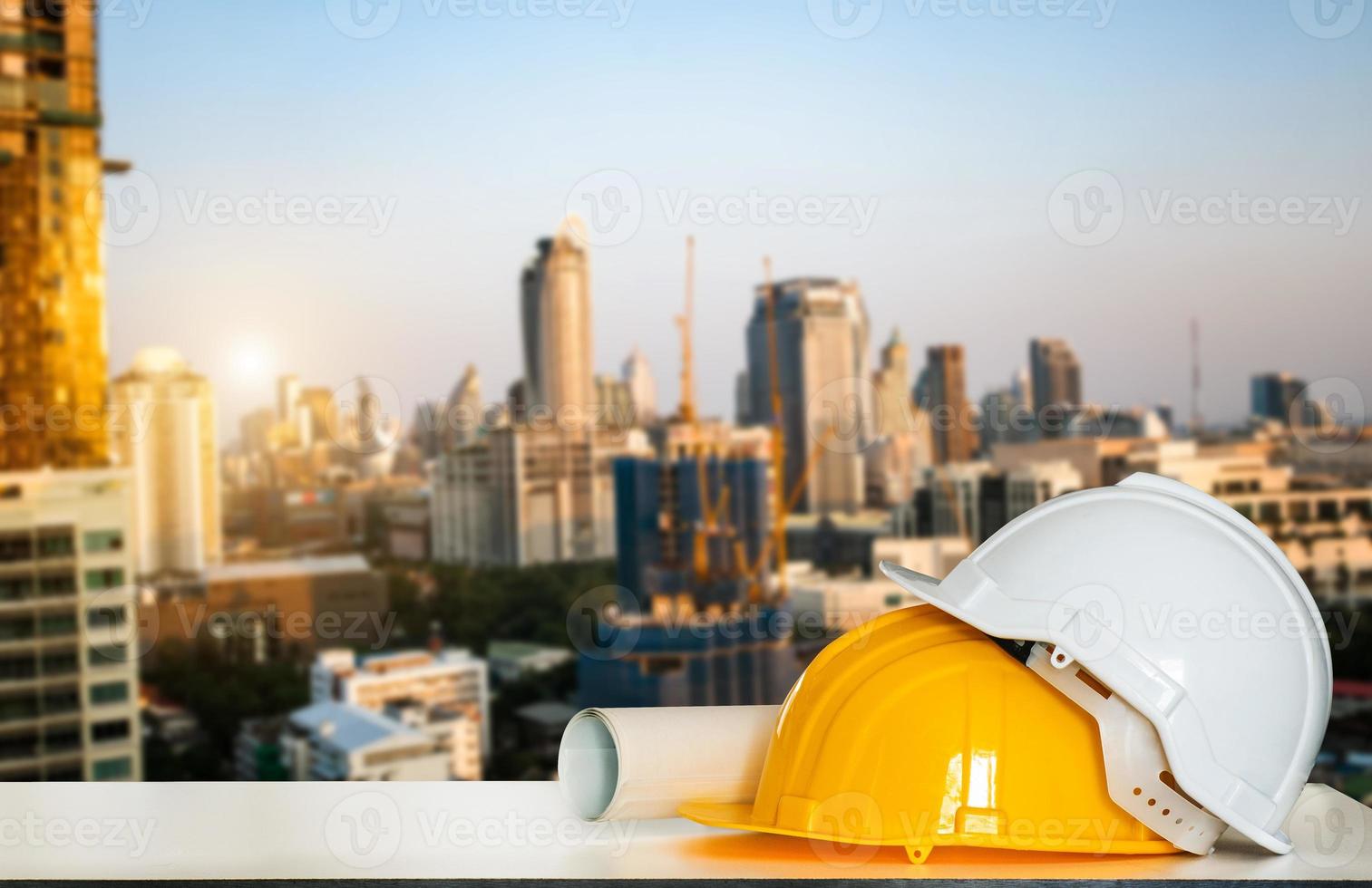 casa de construção e edifício. trabalho de reparação. desenhos para construção e capacete na mesa branca. foto