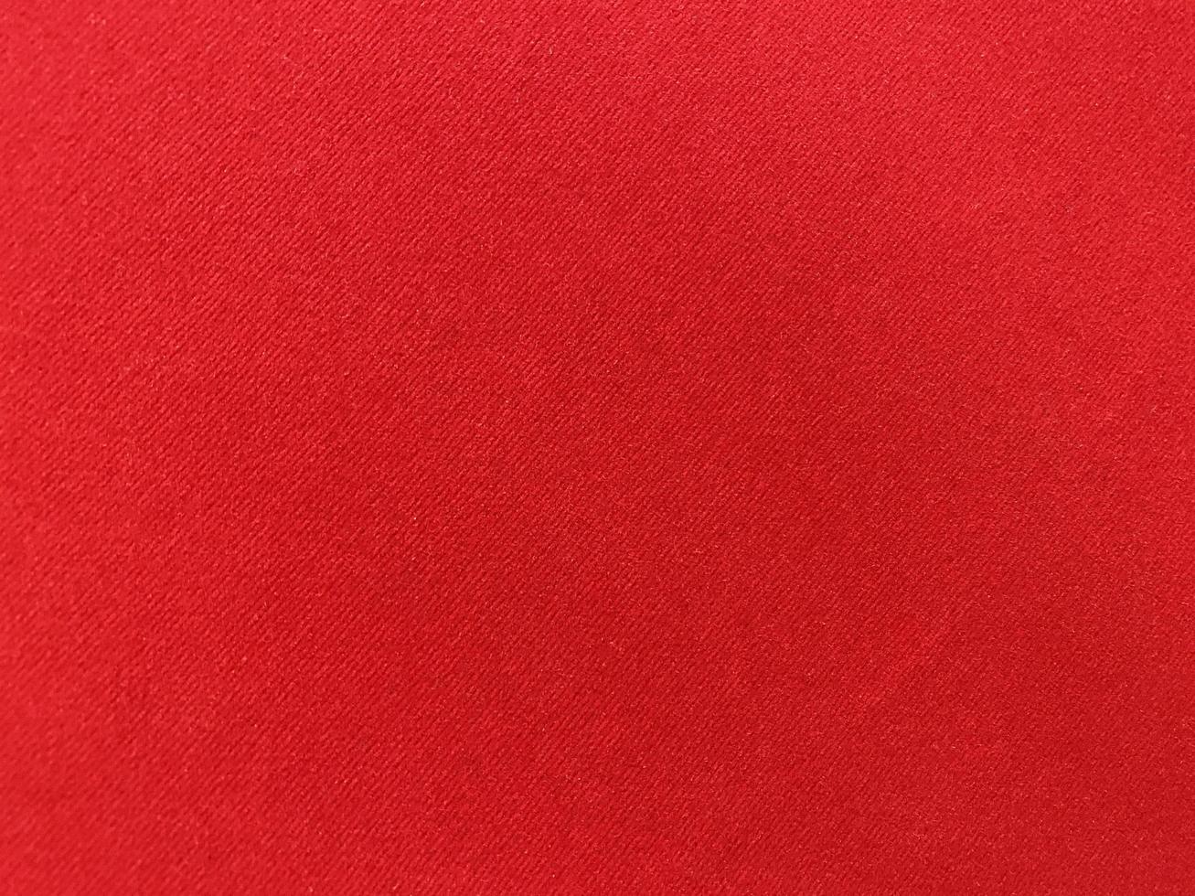 textura de tecido de veludo vermelho escuro usado como plano de fundo. fundo de tecido vermelho vazio de material têxtil macio e liso. há espaço para o texto.. foto