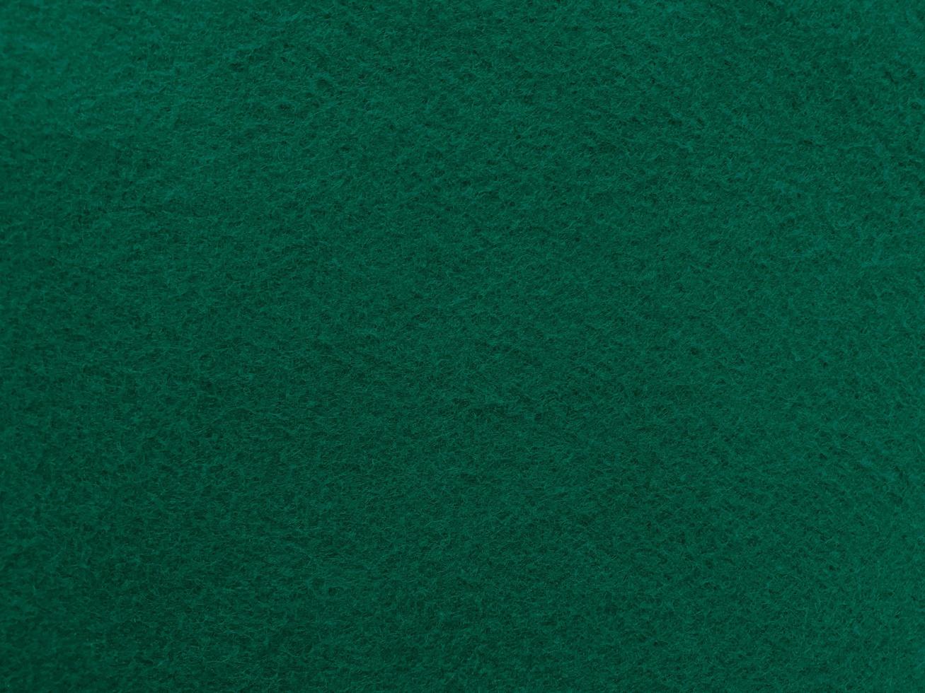 sentiu a textura de fundo do material têxtil áspero macio verde escuro fechar, mesa de pôquer, bola de tênis, toalha de mesa. fundo de tecido novo vazio. foto