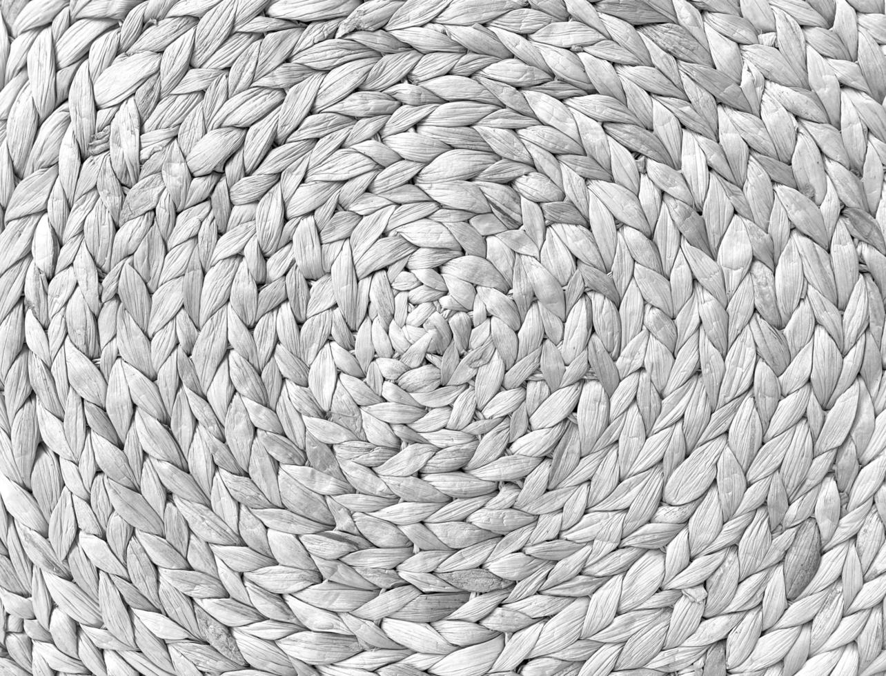 textura de tapete de mesa de palha natural trançada redonda como um fundo branco. quadro completo de padrão de palha bem tecido. com espaço para texto, para um plano de fundo. foto