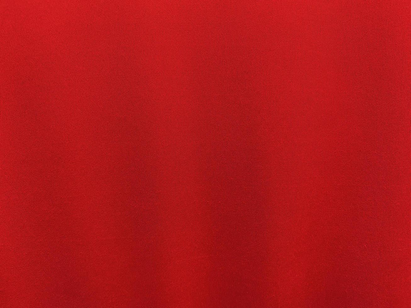 textura de tecido de algodão vermelho usada como plano de fundo. fundo de tecido vermelho vazio de material têxtil macio e liso. há espaço para o texto.. foto